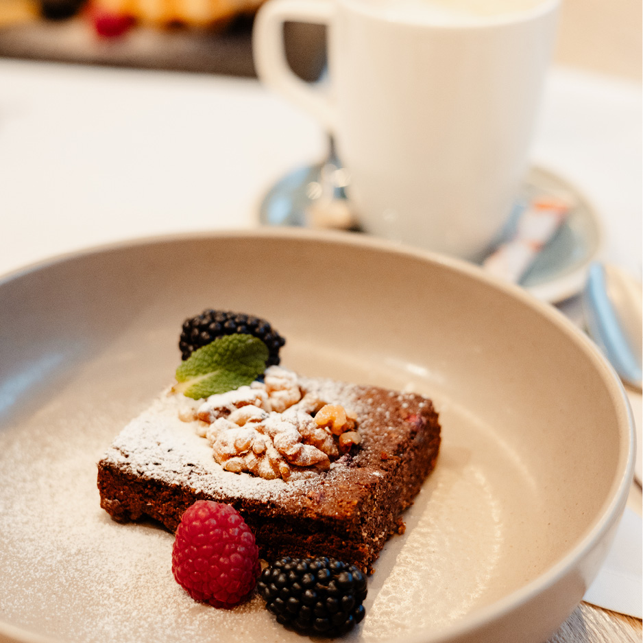 Das Bild zeigt einen Schokobrownie mit Beeren-Dekoration.