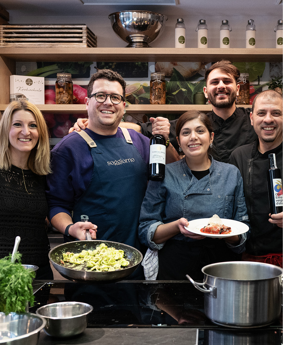 Das Bild zeigt das fröhliche Soggiorno-Team bei einem Kochkurs bei kulinario.