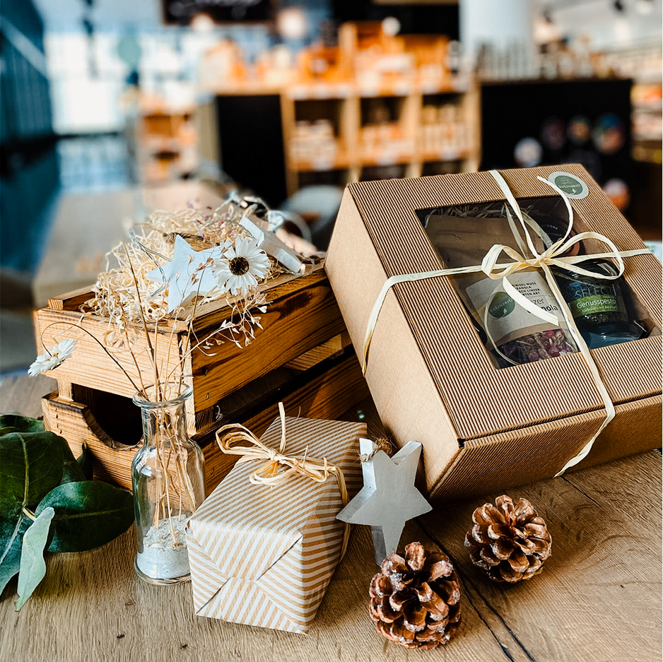 Das Bild zeigt weihnachtlich verpackte Geschenke und etwas Deko.